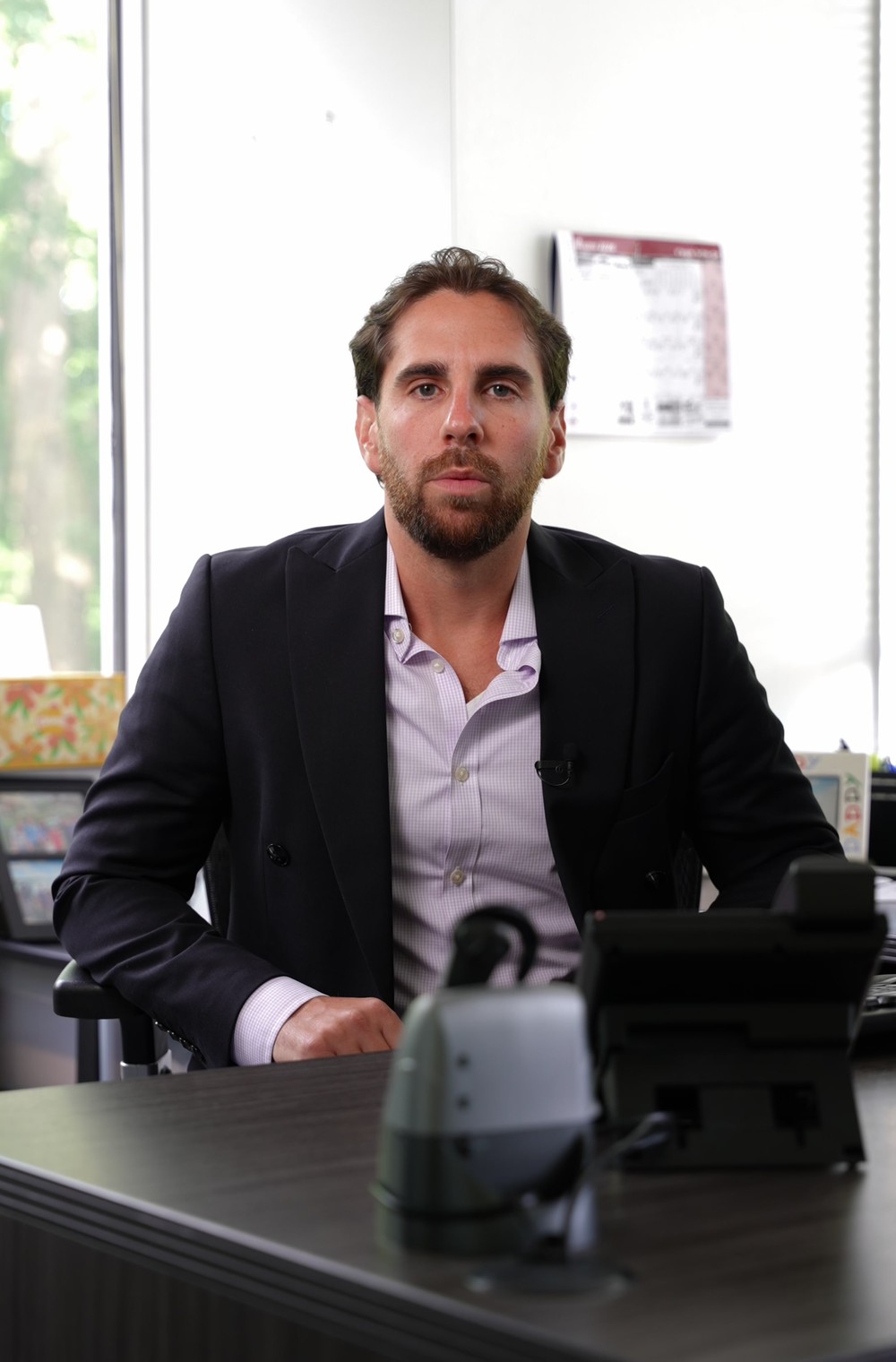 Shlomo Yachnes at his desk, hands clasped